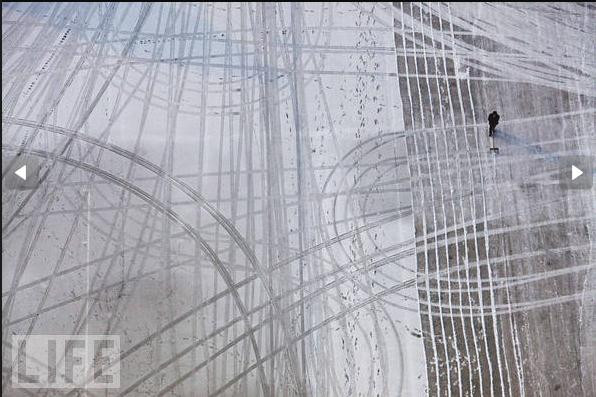 Một người đàn ông dùng xẻng xúc tuyết rơi trong đêm trước tại Bình Nhưỡng, Triều Tiên