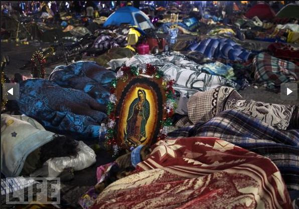 Những người hành hương ngủ bên cạnh bức chân dung Đức Mẹ trong lễ kỷ niệm hàng năm tại Vương Cung Thánh Đường Guadalupe ở Mexico City.