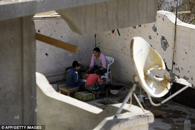 Một gia đình đang ở tạm trong căn nhà đổ nát gần nơi Gaddafi bị bắt Một gia đình đang ở tạm trong căn nhà đổ nát gần nơi Gaddafi bị bắt