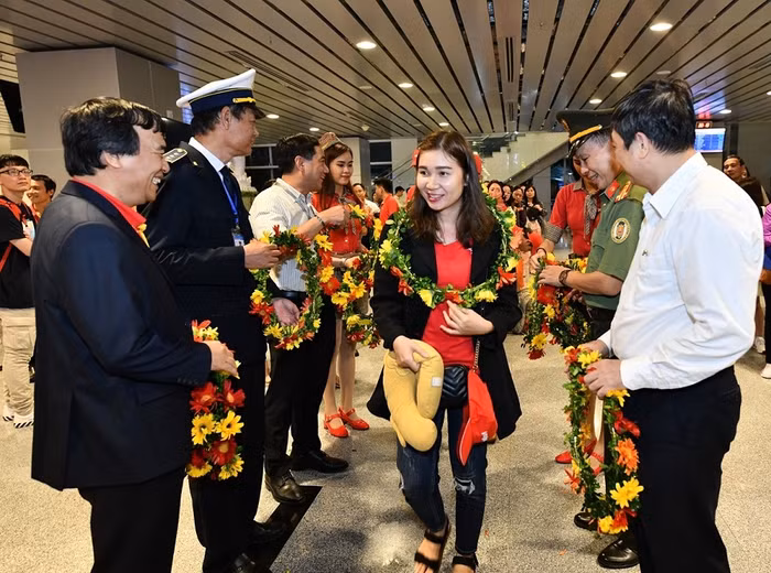 Các hành khách đầu tiên nhận những bó hoa tươi thắm và sẵn sàng cho chuyến bay đến Tokyo.