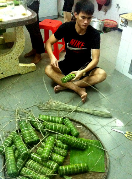 Nam cầu thủ bên mâm bánh đã gói chờ đem nấu chín. Nam cầu thủ bên mâm bánh đã gói chờ đem nấu chín.