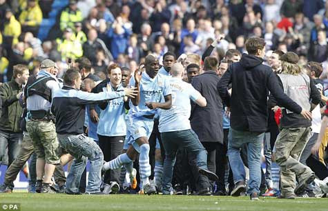 Mario Balotelli ăn mừng giữa đám đông các CĐV tràn vào sân Mario Balotelli ăn mừng giữa đám đông các CĐV tràn vào sân