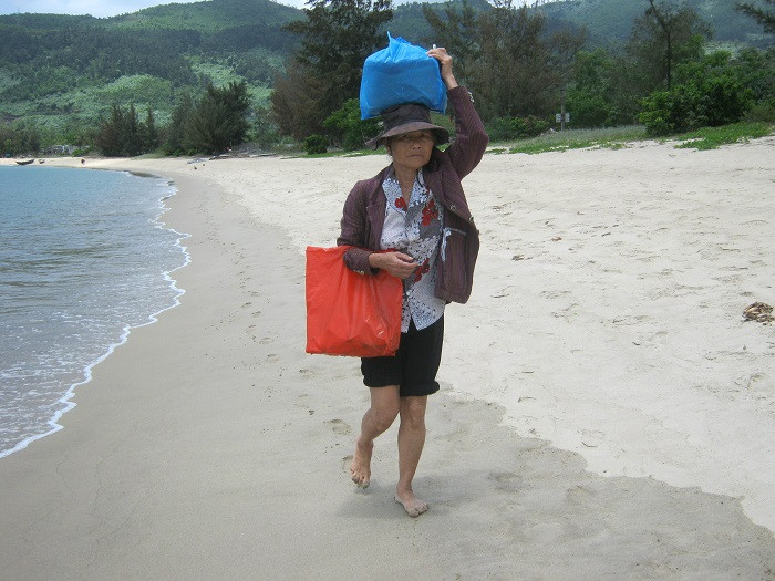 Một người phụ nữ đi chợ về giữa trưa mang thực phẩm vào làng. Một người phụ nữ đi chợ về giữa trưa mang thực phẩm vào làng.