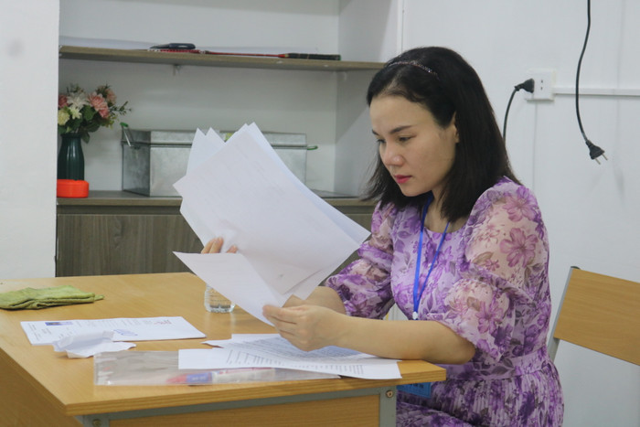 Giám thị tại Điểm thi Trường Trung học cơ sở và Trung học phổ thông Lương Thế Vinh kiểm tra lại các danh sách trước khi gọi thí sinh vào phòng làm thủ tục dự thi. (Ảnh: Doãn Nhàn)