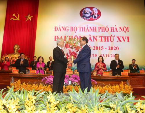 Đồng chí Phạm Quang Nghị, Uỷ viên Bộ Chính trị , Bí thư Tỉhành uỷ Hà Nội tặng hoa chúc mừng Tổng Bí thư Nguyễn Phú Trọng tại Đại hội. Ảnh: TTXVN