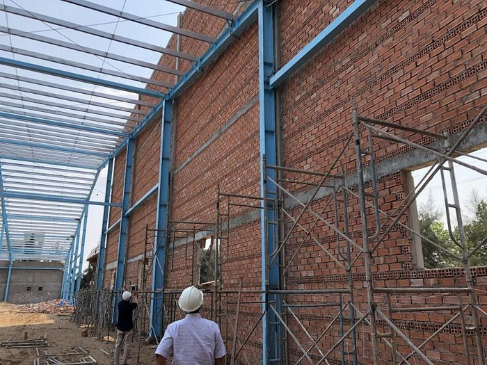 Tường đầu hồi hiện hữu, cao hơn khung mái, không liên kết với khung thép và đã nghiêng ra ngoài là môi nguy hại cần có biện pháp đảm bảo an toàn cho người ra vào khu vực này. Tường đầu hồi hiện hữu, cao hơn khung mái, không liên kết với khung thép và đã nghiêng ra ngoài là môi nguy hại cần có biện pháp đảm bảo an toàn cho người ra vào khu vực này.