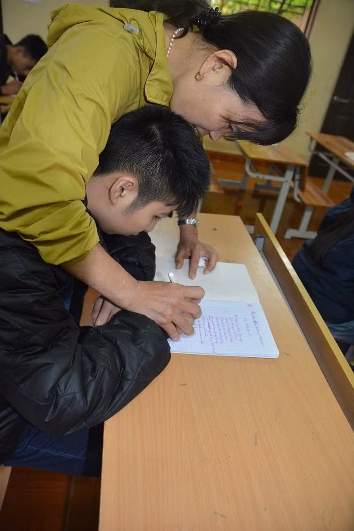 Cô giáo Lê Thị Hòa và nhiều cô giáo khác của lớp học tình thương ở chùa Hương Lan cứ mỗi cuối tuần lại tới lớp dạy văn hóa, dạy làm người cho các em “học sinh đặc biệt” hoàn toàn miễn phí. Ảnh: Công Tiến.