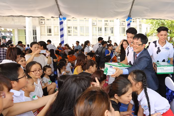Ông Phan Minh Tiên – Giám đốc Điều Hành Vinamilk trao sữa cho các em nhỏ.