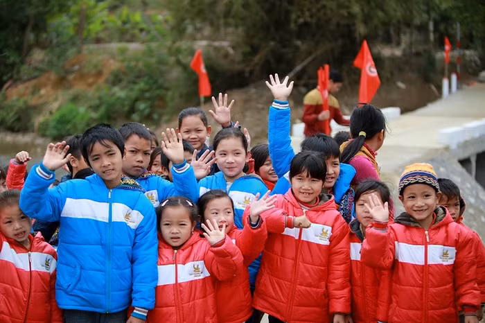 Các em nhỏ hai thôn vui mừng với những chiếc áo mới.