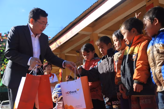 Ông Vũ Hồng Đức – Giám đốc HDBank Lào Cai tận tay áo ấm cho các bé.