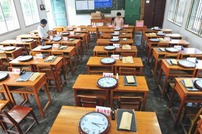 Cận cảnh phòng thi đang được "set up". Mỗi một bàn sẽ có một chiếc đồng hồ đã được căn giờ giống nhau, đề thi và giấy nháp. (Ảnh: Kenh14) Cận cảnh phòng thi đang được "set up". Mỗi một bàn sẽ có một chiếc đồng hồ đã được căn giờ giống nhau, đề thi và giấy nháp. (Ảnh: Kenh14)