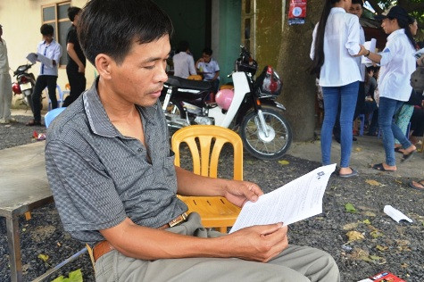 Phụ huynh học chăm chú đọc tờ rơi quảng cáo Phụ huynh học chăm chú đọc tờ rơi quảng cáo