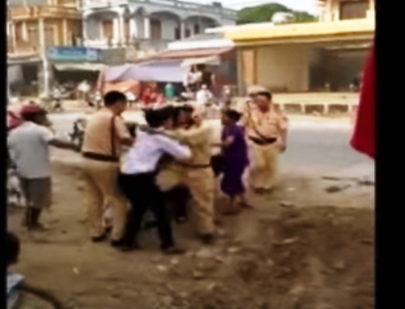 Nam thanh niên mặc áo trắng bị một CSGT túm cổ, lên gối khi anh này có ý định can ngăn Nam thanh niên mặc áo trắng bị một CSGT túm cổ, lên gối khi anh này có ý định can ngăn