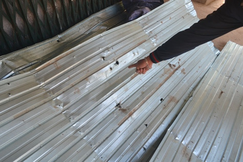 Mái tôn trên trần nhà bị thủng nhiều lỗ do vụ nổ gây ra