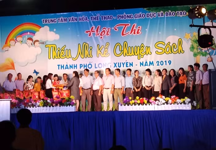 Ban tổ chức trao cờ lưu niệm cho các đơn vị tham gia kể chuyện sách ( Ảnh: Văn Khánh)