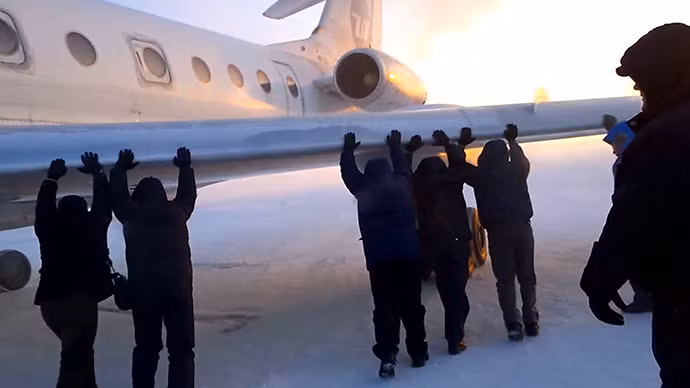 Hành khách chung tay đẩy máy bay bị kẹt trong băng.