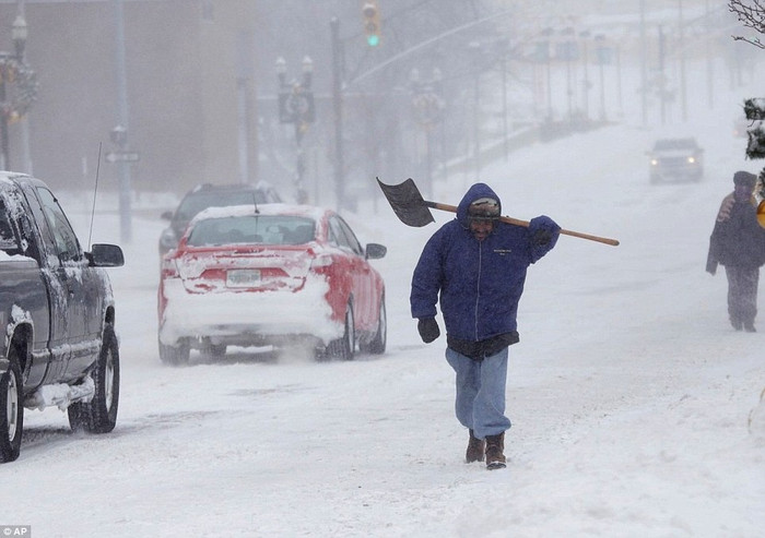 Một người đàn ông ở Flint, Michigan, mang xẻng của mình khi đi bộ trên tuyết. Một người đàn ông ở Flint, Michigan, mang xẻng của mình khi đi bộ trên tuyết.