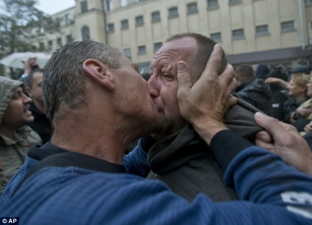 Một người đàn ông hôn một người đàn ông khác vừa được giải thoát.