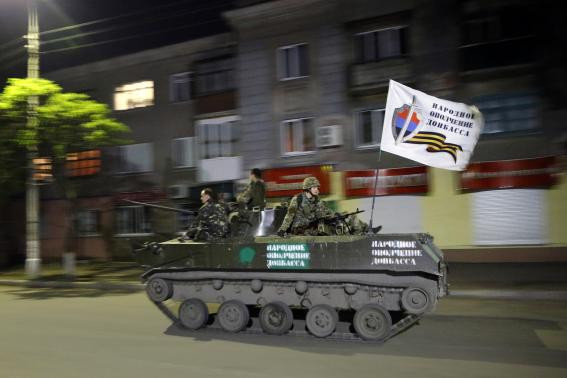 Xe bọc thép với các tay súng ủng hộ Nga tuần hành trên đường phố Slaviansk.