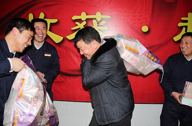 Nhân viên công ty phát triển nhà đất ở tỉnh Hải Nam, Trung Quốc vác những bao tiền thưởng Tết trong sự sung sướng. Nhân viên công ty phát triển nhà đất ở tỉnh Hải Nam, Trung Quốc vác những bao tiền thưởng Tết trong sự sung sướng.