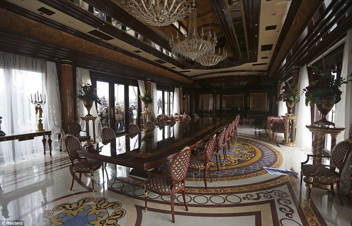 Bàn ăn lớn với đèn chùm hai tầng bên trong dinh thự. Bàn ăn lớn với đèn chùm hai tầng bên trong dinh thự.