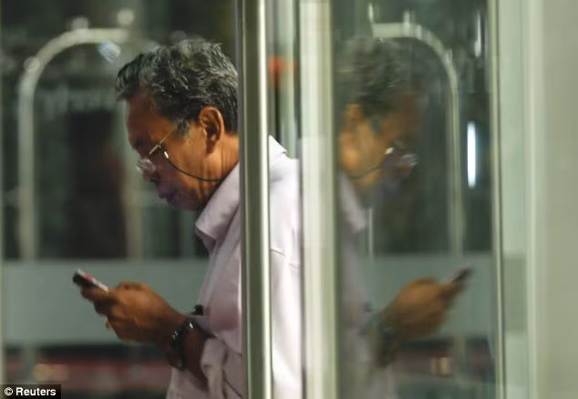 Selamat Omar, cha của một hành khách đang đọc tin nhắn tại khách sạn nơi ông đang ở cùng các thân nhân khác