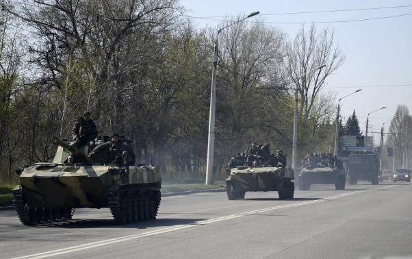 Ảnh: Đội quân mặt nạ có vũ trang lái xe bọc thép mang cờ Nga di chuyển bên ngoài thị trấn Kramatorsk hôm 16/4. Ảnh: Đội quân mặt nạ có vũ trang lái xe bọc thép mang cờ Nga di chuyển bên ngoài thị trấn Kramatorsk hôm 16/4.