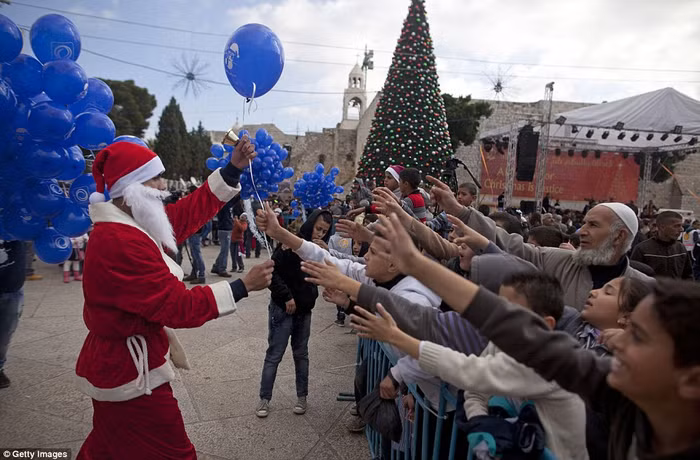 Ông già Noel phát bóng cho trẻ em ở Bethlehem.