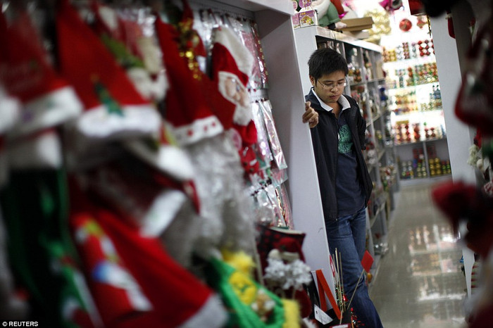 Một người đàn ông chờ khách trong cửa hàng của mình.