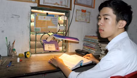 Nguyễn Đức Ngà bên góc học tập đơn sơ ở nhà. Ảnh Liêm Thanh