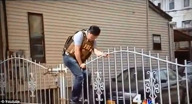 Nhân viên FBI chật vật leo qua cánh cổng.
