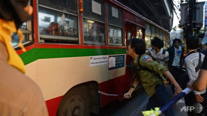 Người biểu tình quá khích tấn công xe bus của phe áo đỏ ủng hộ chính phủ.