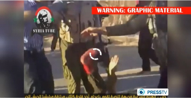 Viên chỉ huy FSA bị đám đông vũ trang xô đẩy ngã xuống đất trước khi bị họ bắn chết. Viên chỉ huy FSA bị đám đông vũ trang xô đẩy ngã xuống đất trước khi bị họ bắn chết.