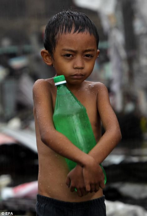 Một cậu bé Philippines co ro trong mưa lớn hậu siêu bão Haiyan. Một cậu bé Philippines co ro trong mưa lớn hậu siêu bão Haiyan.