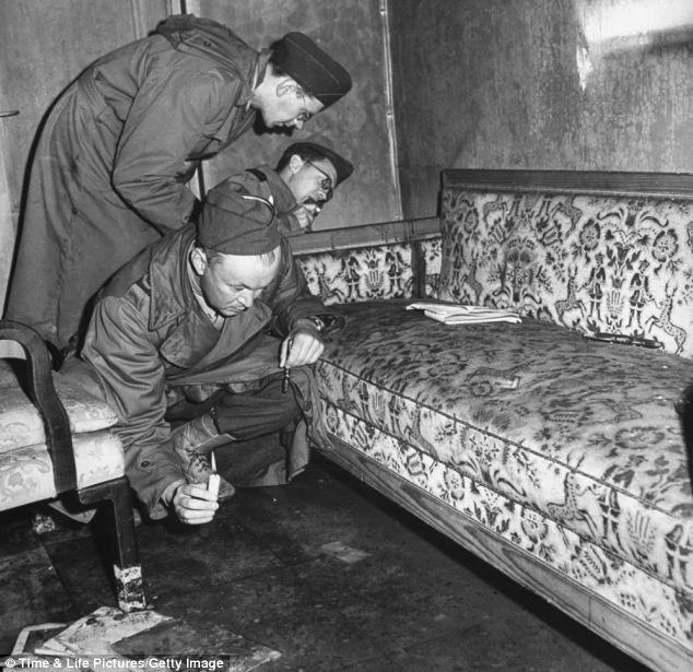 Các chiến sĩ Hồng quân kiểm tra chiếc ghế băng dài đẫm máu, nơi Hitler tự sát cùng vợ, và dùng nến tìm kiếm bằng chứng tự tử trên sàn nhà. Các chiến sĩ Hồng quân kiểm tra chiếc ghế băng dài đẫm máu, nơi Hitler tự sát cùng vợ, và dùng nến tìm kiếm bằng chứng tự tử trên sàn nhà.