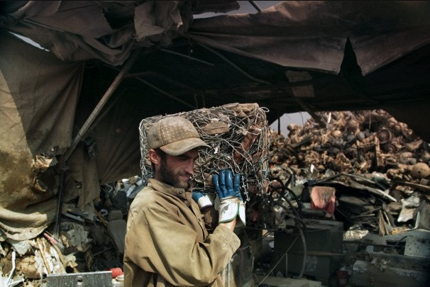 Một người đàn ông thu thập đám dây thép gai đã được nén thành một khối vuông vắn. Một người đàn ông thu thập đám dây thép gai đã được nén thành một khối vuông vắn.