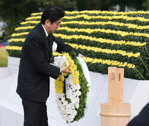 Thủ tướng Nhật Shinzo Abe đặt vòng hoa tưởng niệm tại công viên tưởng niệm hòa bình ở thành phố Hiroshima ngày 6.8 - Ảnh: AFP Thủ tướng Nhật Shinzo Abe đặt vòng hoa tưởng niệm tại công viên tưởng niệm hòa bình ở thành phố Hiroshima ngày 6.8 - Ảnh: AFP