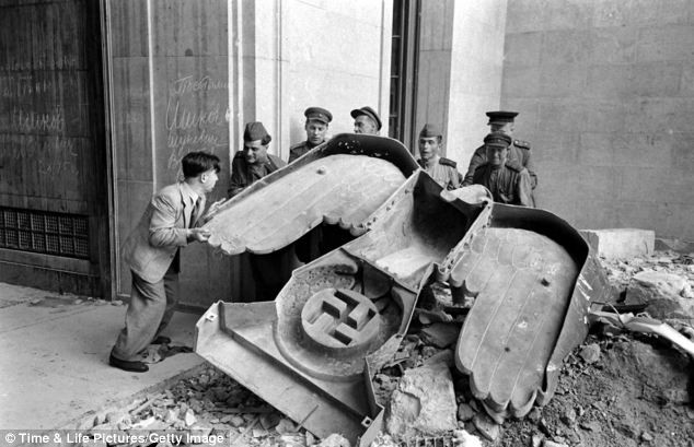 Những người lính Hồng quân đang cố khiêng bức tượng đại bàng bằng đồng của Hitler. Những người lính Hồng quân đang cố khiêng bức tượng đại bàng bằng đồng của Hitler.