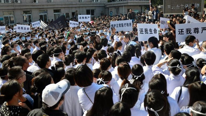 Các bác sĩ, nhân viên y tế Trung Quốc biểu tình trong khi bị đám đông người dân vây quanh.
