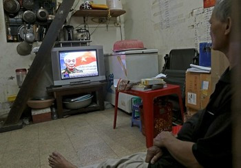 Một người dân Hà Nội xem bản tin về Tướng Giáp qua đời trên truyền hình Việt Nam. Sự ra đi đột ngột của Đại tướng dẫu biết trước, nhưng vẫn để lại rất nhiều khoảng trống khó có thể lấp đầy trong lòng nhân dân Việt Nam.