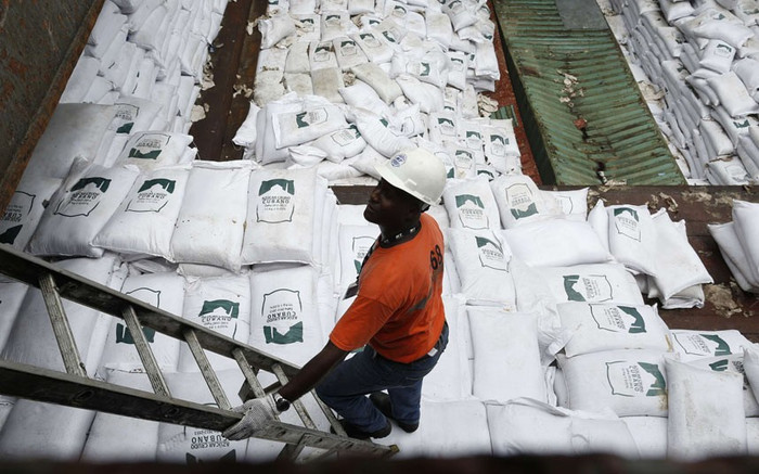 Một nhân viên an ninh Panama đứng trên các bao đường mang logo nhà sản xuất Cuba. Một nhân viên an ninh Panama đứng trên các bao đường mang logo nhà sản xuất Cuba.