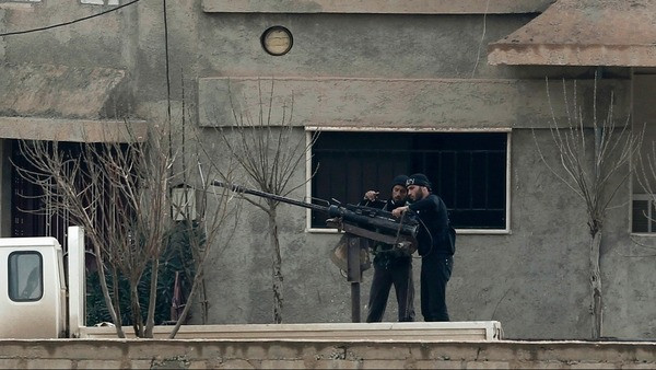 Phiến quân đứng trong thị trấn Ras al-Ain của Syria được nhìn thấy từ thị trấn biên giới Ceylanpinar, tỉnh Sanliurfa, của Thổ Nhĩ Kỳ.