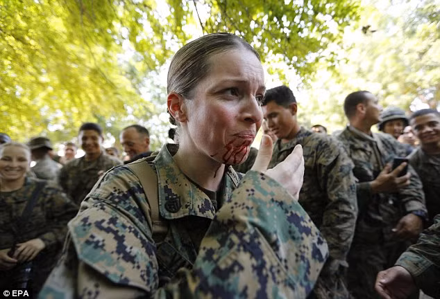 Nữ binh sĩ Mỹ lau miệng sau khi được uống huyết rắn.