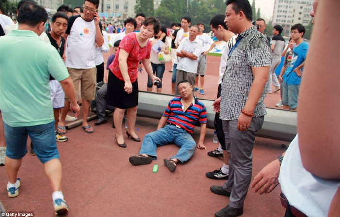 Một trong 7 người bị thương ngồi trên đất chờ đợi giúp đỡ y tế.