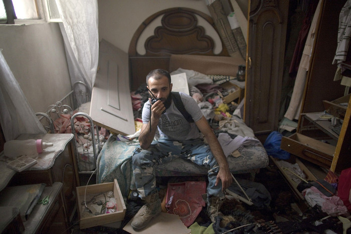 Một tay súng nói chuyện qua điện đàm bên trong tòa nhà vừa chiếm đóng tại Aleppo ngày 9/7. Một tay súng nói chuyện qua điện đàm bên trong tòa nhà vừa chiếm đóng tại Aleppo ngày 9/7.