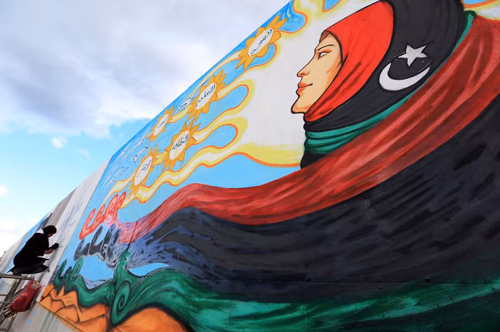 Một nghệ sĩ vẽ tranh trên tường của một dinh thự của Gaddafi ngày 9/12/2012.