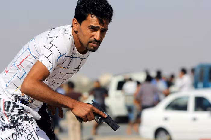 Người biểu tình Libya cầm một khẩu súng trong cuộc đụng độ giữa những người biểu tình và quân đội tại Benghazi ngày 8/6/2013.