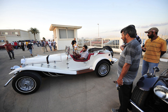 Du khách xem một người đàn ông ngồi trong chiếc xe Mercedes-Benz cổ tại triển lãm xe hơi ở Benghazi ngày 3/7/2013. Du khách xem một người đàn ông ngồi trong chiếc xe Mercedes-Benz cổ tại triển lãm xe hơi ở Benghazi ngày 3/7/2013.