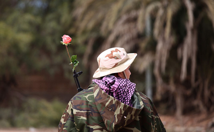 Một thành viên lực lượng an ninh Libya cắm một bông hòng trong nòng súng trường tại Benghazi ngày 16/2/2013. Một thành viên lực lượng an ninh Libya cắm một bông hòng trong nòng súng trường tại Benghazi ngày 16/2/2013.