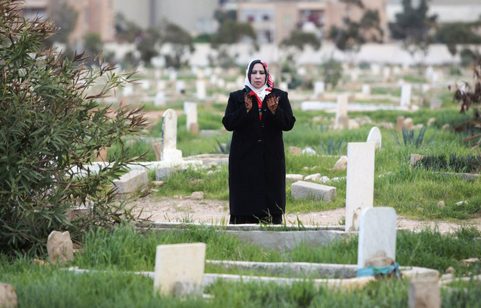 Một người phụ nữ đọc một câu kinh Koran tại ngôi mộ của con trai bà, người đã chết trong cuộc xung đột bắt đầu từ ngày 17/2/2011 tại một nghĩa trang ở Benghazi, ngày 17/2/2013. Một người phụ nữ đọc một câu kinh Koran tại ngôi mộ của con trai bà, người đã chết trong cuộc xung đột bắt đầu từ ngày 17/2/2011 tại một nghĩa trang ở Benghazi, ngày 17/2/2013.